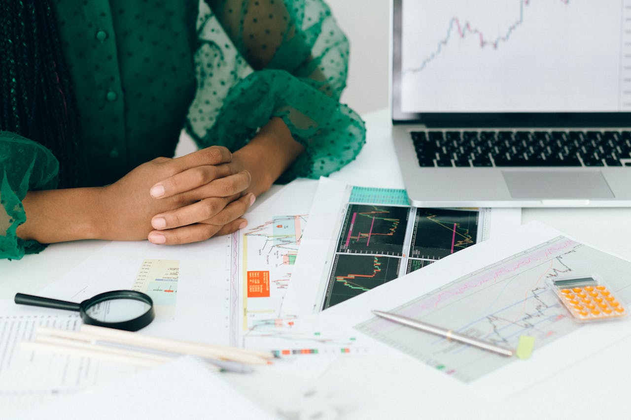 gallery-02 A person analyzes financial charts and graphs at a desk, indicating business trading activity.